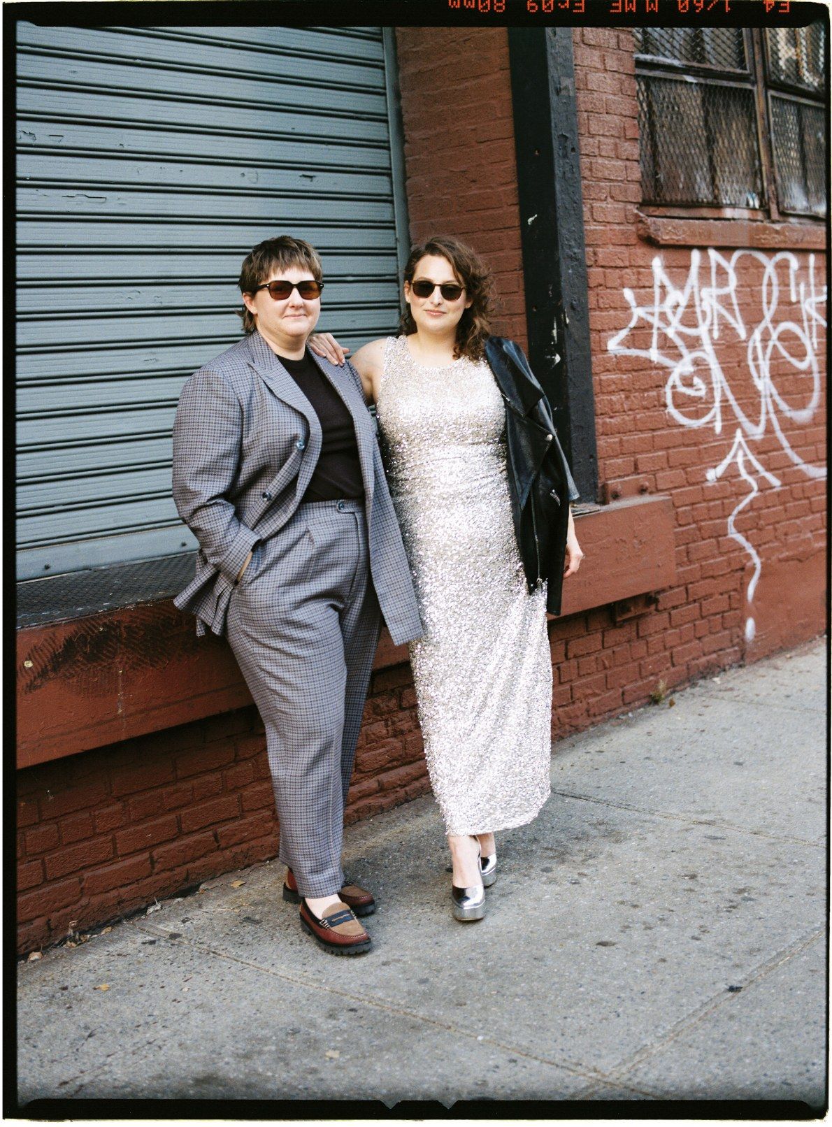 Estelle and Mackenzie against the brick, sequins and houndstooth