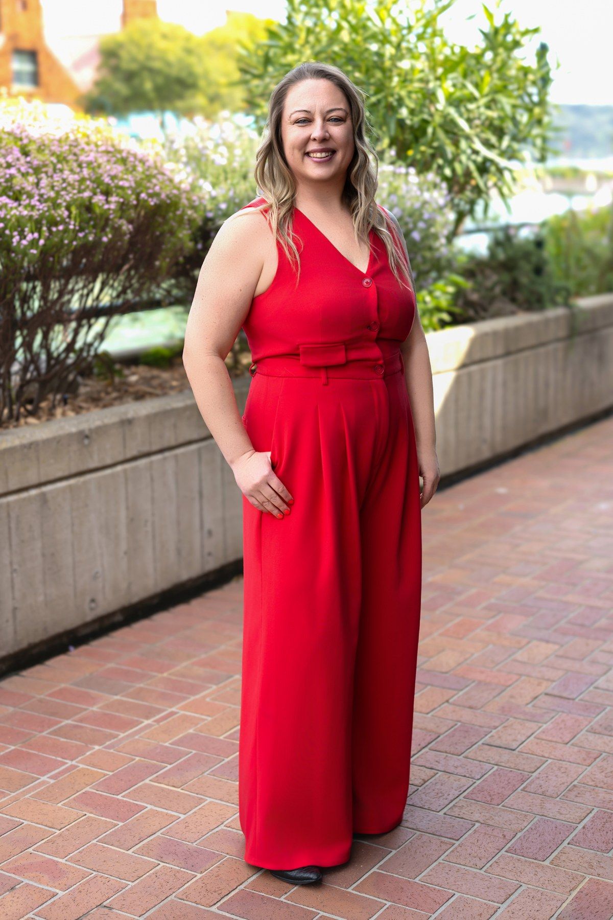 Michele in a red vest and wide-leg trousers