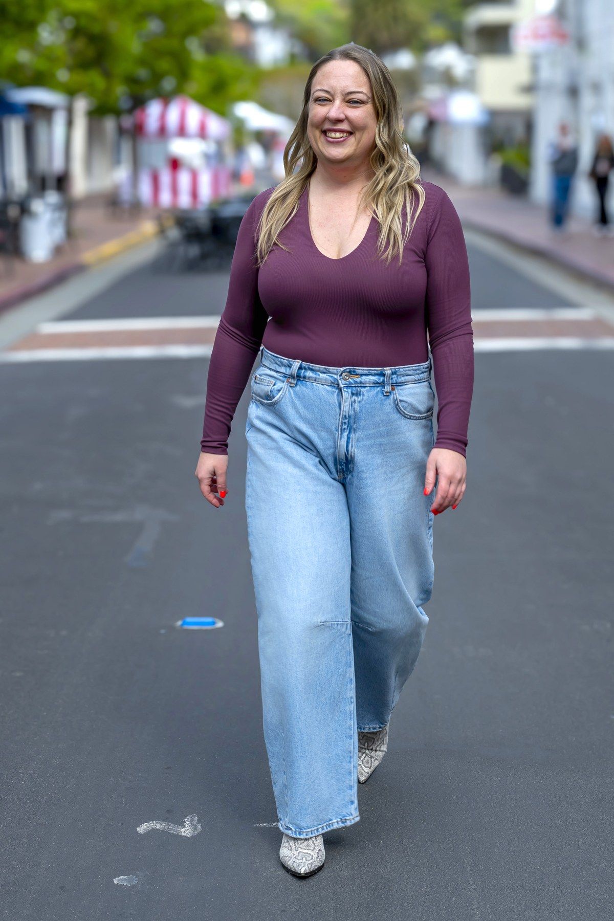 Michele walking in a plum top and light denim